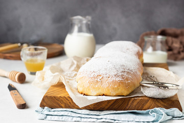 Poppy seed roll or strudel on wooden board sprinkled with powdered sugar. Traditional polish festive pastry – Makowiec.