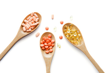 vitamin supplement in wooden spoon on white background.