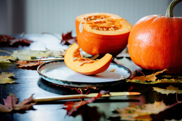 cut pumpkin on a plate with cutlery on the table