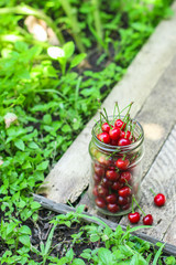 cherries in a transparent jar (red and ripe fruits, harvest) menu concept. food background. copy space. Top view