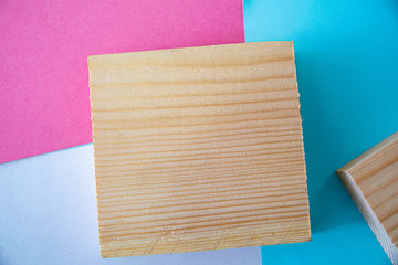 A wood square on colored background, with room to put a draw on the wooden block