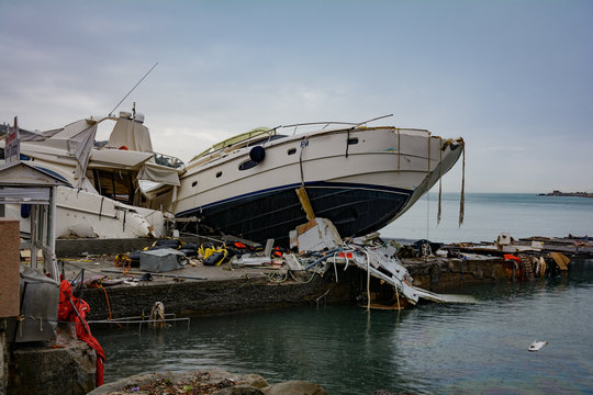 Barche distrutte da una forte mareggiate appoggiate su un molo