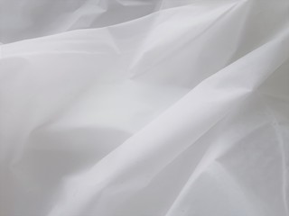 Wrinkled white fabric. Close-up photo. Abstract light background.