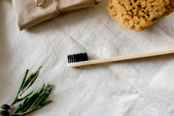 Fototapeta na wymiar eco natural bamboo toothbrushes in glass on rustic background with greenery. sustainable lifestyle concept. zero waste home. bathroom essentials, plastic free items