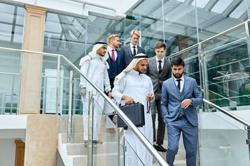 Confident business people after business conference, meeting. Successful deal, sheikhs and caucasians