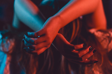 Close up on female young woman's girl's beautiful hands woman lying on the bed with black nail...