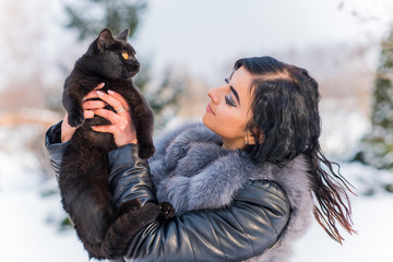 Holidays with lovely pet, woman with a black cat, celebrate Christmas time or New Year