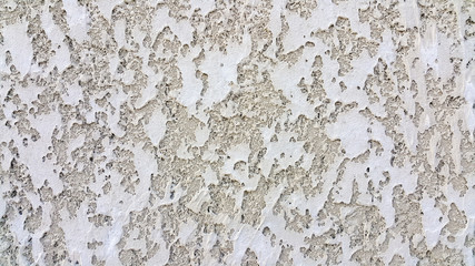 The facade of the building, plaster gray and textured background on the wall, smooth in places.