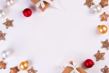 Christmas and New Year holiday composition. Mock up frame with gift box, balls and stars on white background. Flat lay, top view festive concept.