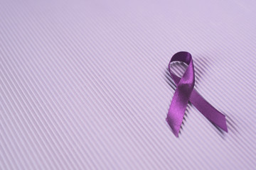 Purple ribbon on purple background. Symbol of EPILEPSY awareness