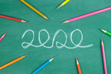 Fototapeta na wymiar chalk write 2020 text and color pencil on green chalk board