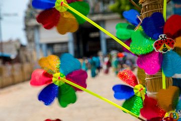 vendor selling colorful plastic windmill on Indian temple festival time.