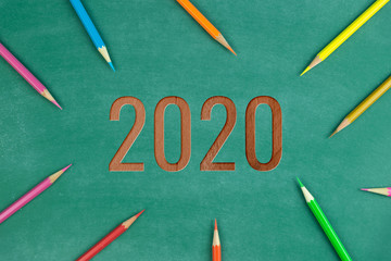 Fototapeta na wymiar wood text 2020 and color pencil on green chalk board