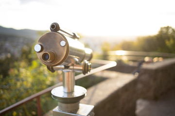 Obraz premium Münzfernrohr blickt in den Sonnenuntergang auf die Stadt