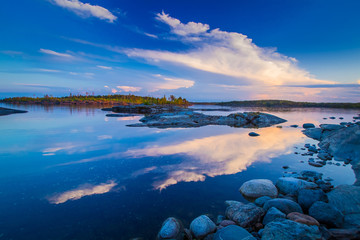 Clouds are reflected in the lake. Skerries of lake Ladoga. Panorama Of Karelia. Rocky Islands in...