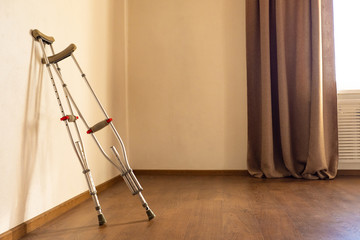 Crutches are in the room. Creating an enabling environment for persons with disabilities. Assistance to people with disabilities. Call to protect health.