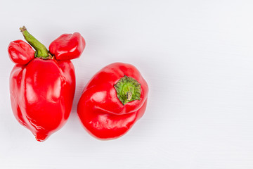 Trendy ugly organic farm vegetables - sweet bell peppers with mutations on white background. Concept zero waste production in food industry and a world without starvation. Copy space. Top view.