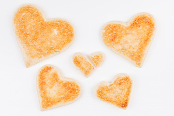 Group of toasted bread hearts with one broken heart together on white background. The concept of support in big family.