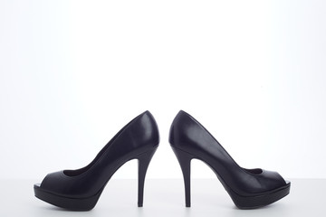 black high-heeled shoes on white