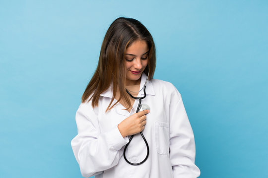 Young brunette girl over isolated blue background with doctor gown