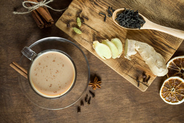 Masala chai tea in one glass Cup on wooden background in rustic style. Traditional Indian drink with milk, black tea and spices. Copy space, top view, close-up