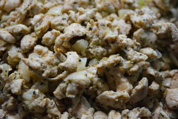 Finely chopped pieces of homemade chicken breast, fried and stewed with onions and sunflower oil. Slices of delicious, juicy chicken lying on a black skillet while frying.