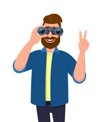 Trendy bearded man in casual wear looking through binoculars and gesturing, making victory, V, peace or number two sign with hand finger. Male character is holding a binocular. Modern lifestyle.