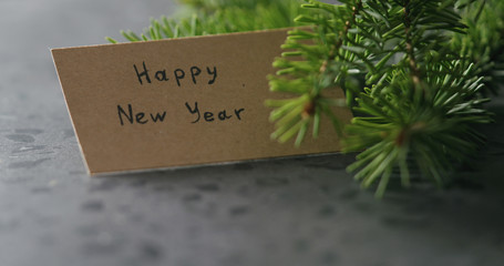 happy new year card next to spruce twig