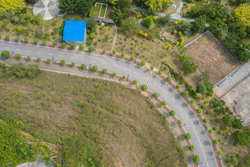 Naklejka premium Aerial view of a curved asphalt road landscape in the park