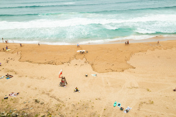 Aerial view of sandy beach with waves and unidentified people relaxing long exposure picture