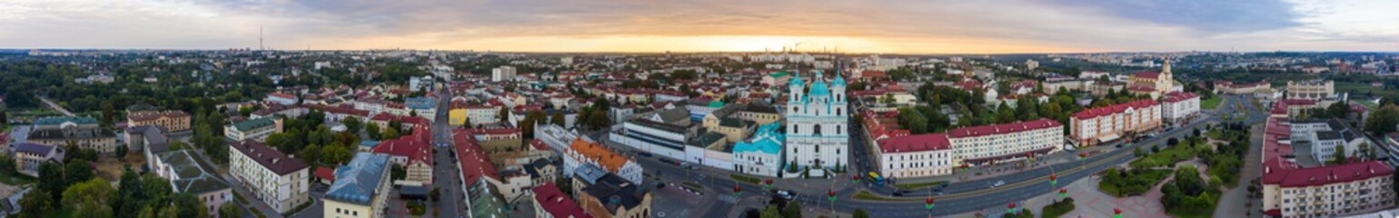 St. Francis Xavier Cathedral And Traffic In Mostowaja And Kirova Streets At Evening In Night Illuminations Lights. Sunset Sky. Grodno city in Belarus