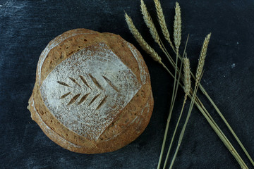 Fresh homemade bread. round bread on a dark background. Mother dough bread. Homemade bread sourdough, rustic baked bread