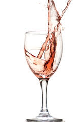 a splash of red wine in a glass on a white background