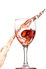 a splash of red wine in a glass on a white background