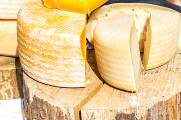 mix of various varieties of hard cheese on a wooden board.