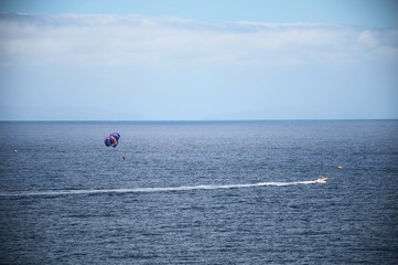 Parasailing, parachute pulled by a motorboat in the ocean, island of Madeira