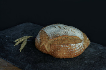 Fresh homemade bread. round bread on a dark background. Mother dough bread. Homemade bread sourdough, rustic baked bread