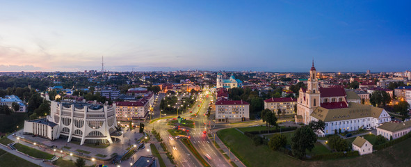 Grodno Regional Drama Theater and Holy Cross Church And Traffic In Mostowaja And Kirova Streets in the morning light. Grodno city in Belarus. Aerial view from a drone