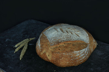 Fresh homemade bread. round bread on a dark background. Mother dough bread. Homemade bread sourdough, rustic baked bread