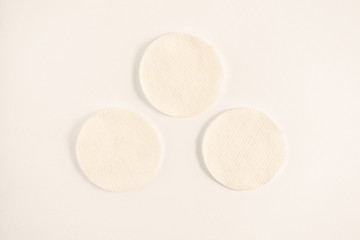Fototapeta na wymiar Three white sponges to clean skin or makeup removing. Light blank background with triangle group