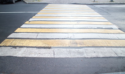 pedestrian crossing across the road with wet asphalt