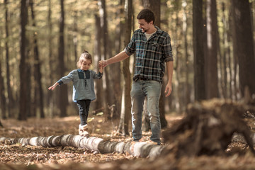 Fototapeta premium Dad and daughter walking in the autumn forest.