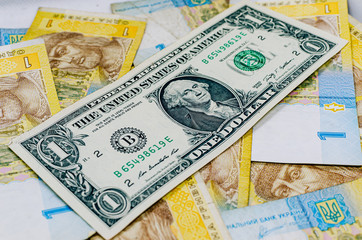 One dollar against the background of one hryvnia. The dollar against the hryvnia, rising and falling.