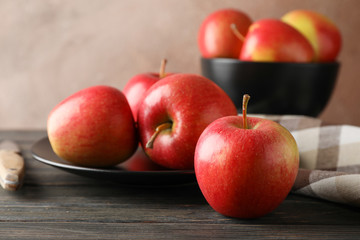 Composition with apples, plate and kitchen towel on wooden background, copy space