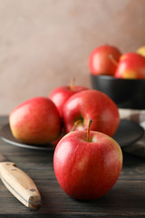 Composition with apples, plate and kitchen towel on wooden background, copy space