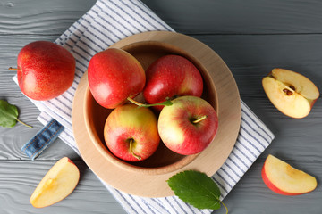Apples in bowl on wooden background, top view 
