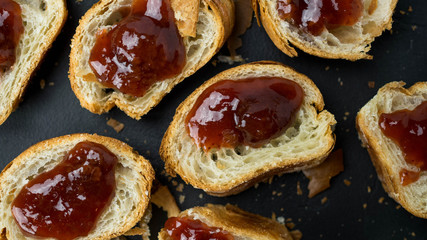 Croissant z dżemem leżący na ciemnym tle. Widok z góry, zbliżenie.