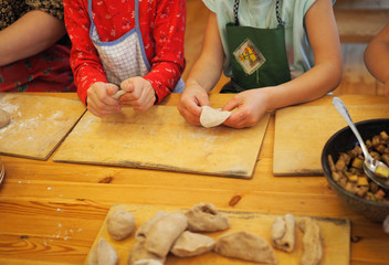 children work together to roll out dough .