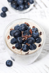 bircher muesli with fresh blueberries on white table, top view closeup