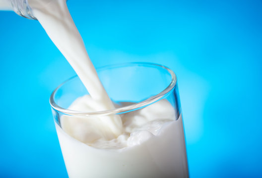 milk pouring from bottle into glass